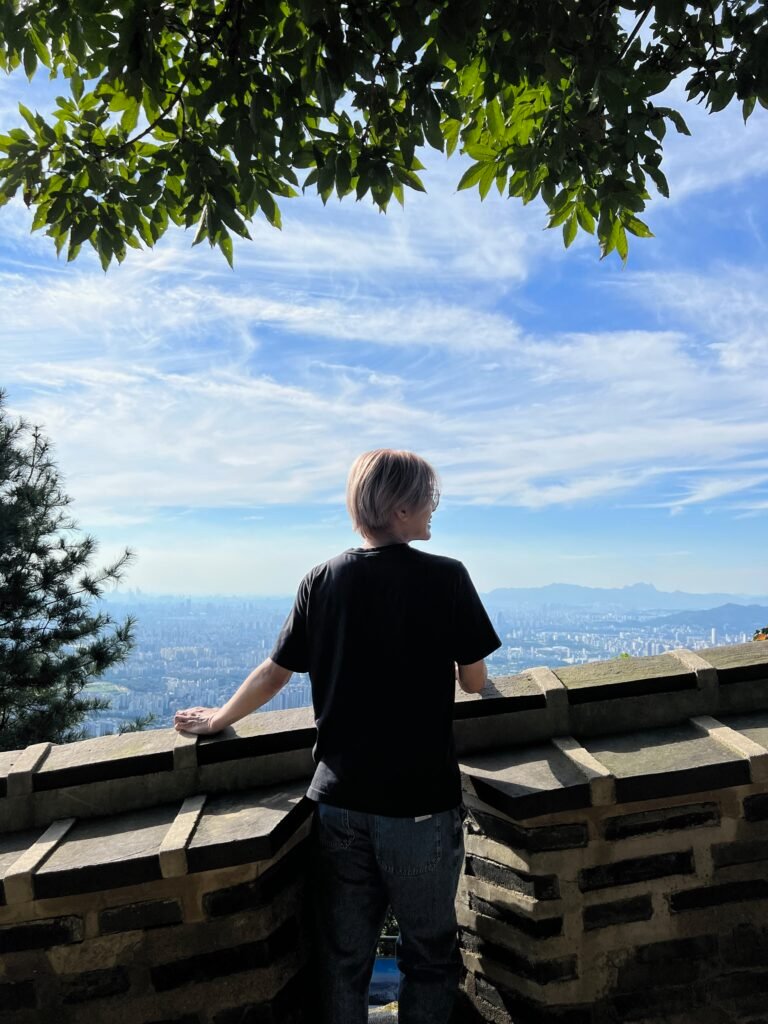David standing at Namhansanseong Fortress overlooking the Seoul city skyline.