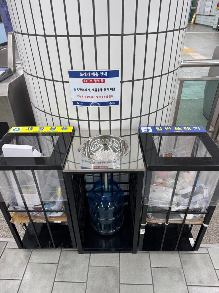 Public trash bin inside a Seoul subway station with liquid disposal.