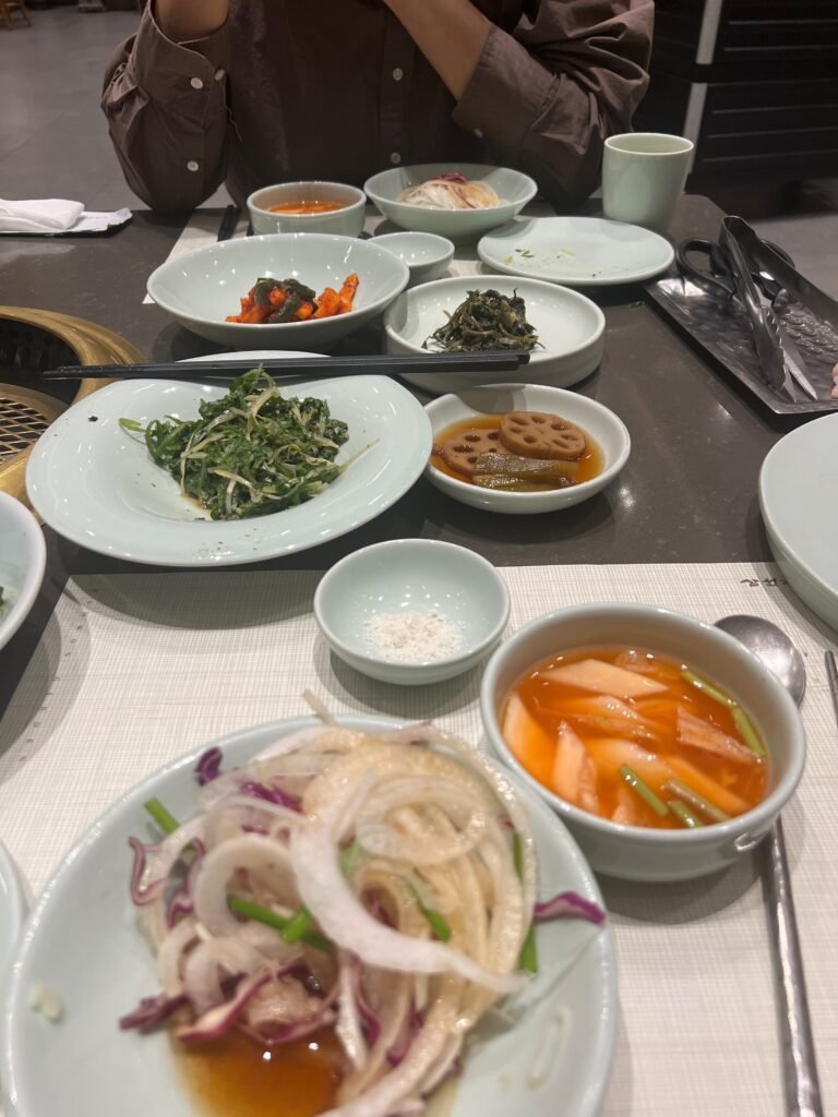 Traditional Korean BBQ side dishes (Banchan) on a metal table.